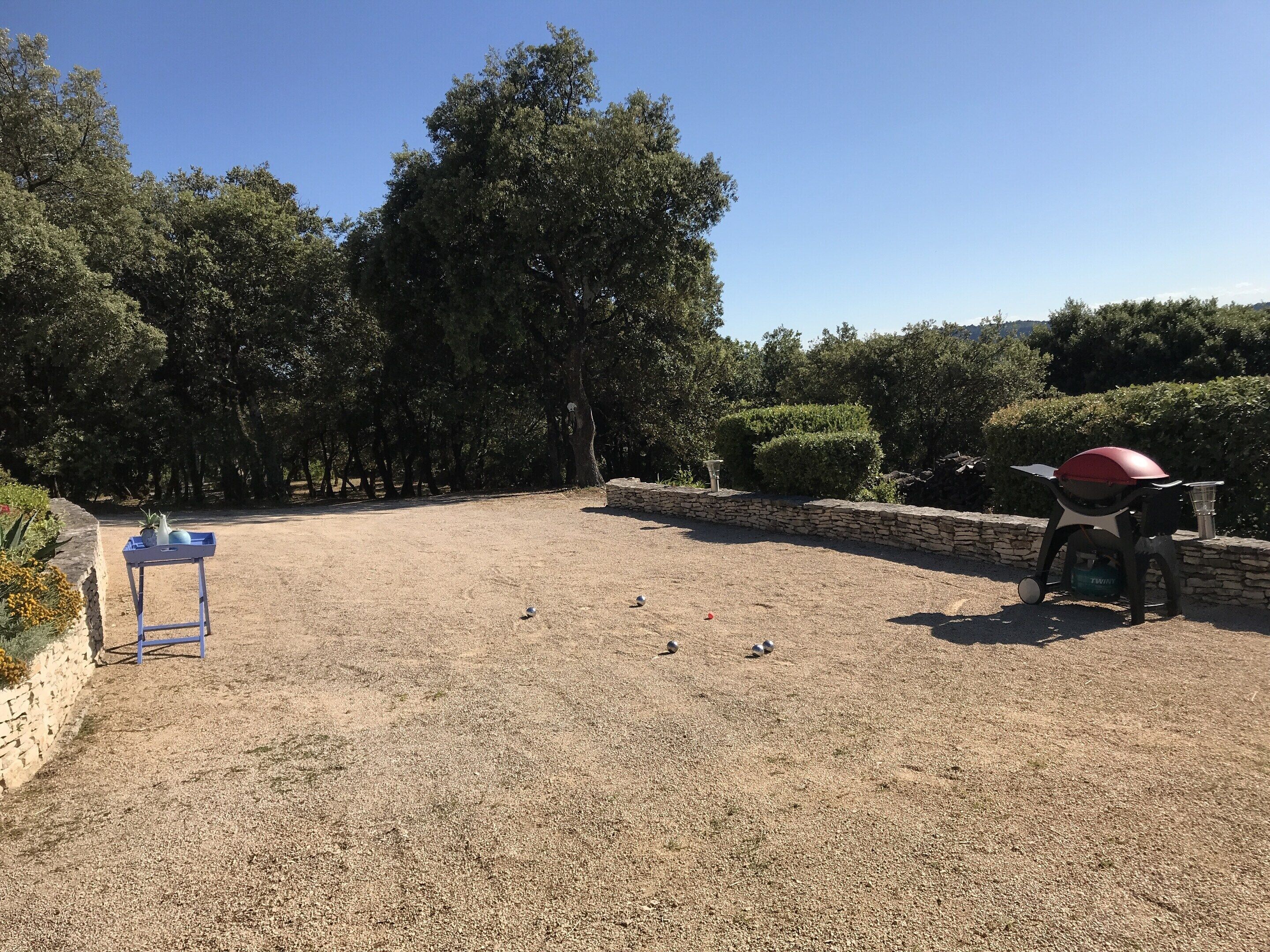 Zona de grava amb una barbacoa i una taula amb una planta.