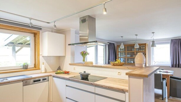 A modern kitchen with white cabinets, a wooden countertop, and a built-in dishwasher. - Quiet Villa with Hot Tub & Sauna (Somme-Leuze)