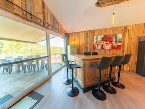 Eine moderne Küche mit einer Holzwand, einem großen Fenster und einer Bar mit Hockern.