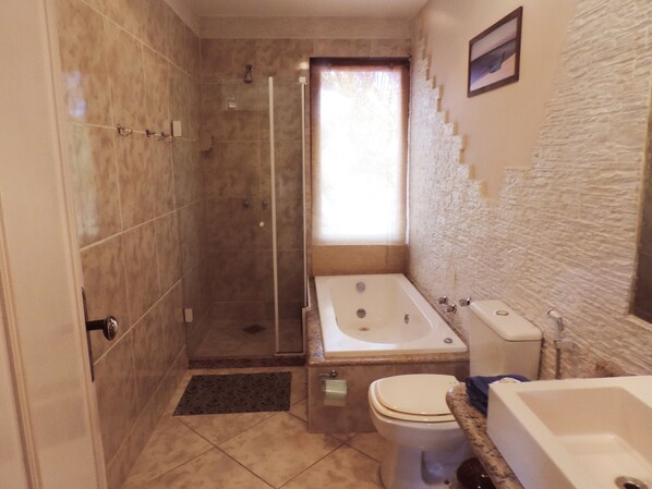 Un baño con ducha, inodoro y bañera.