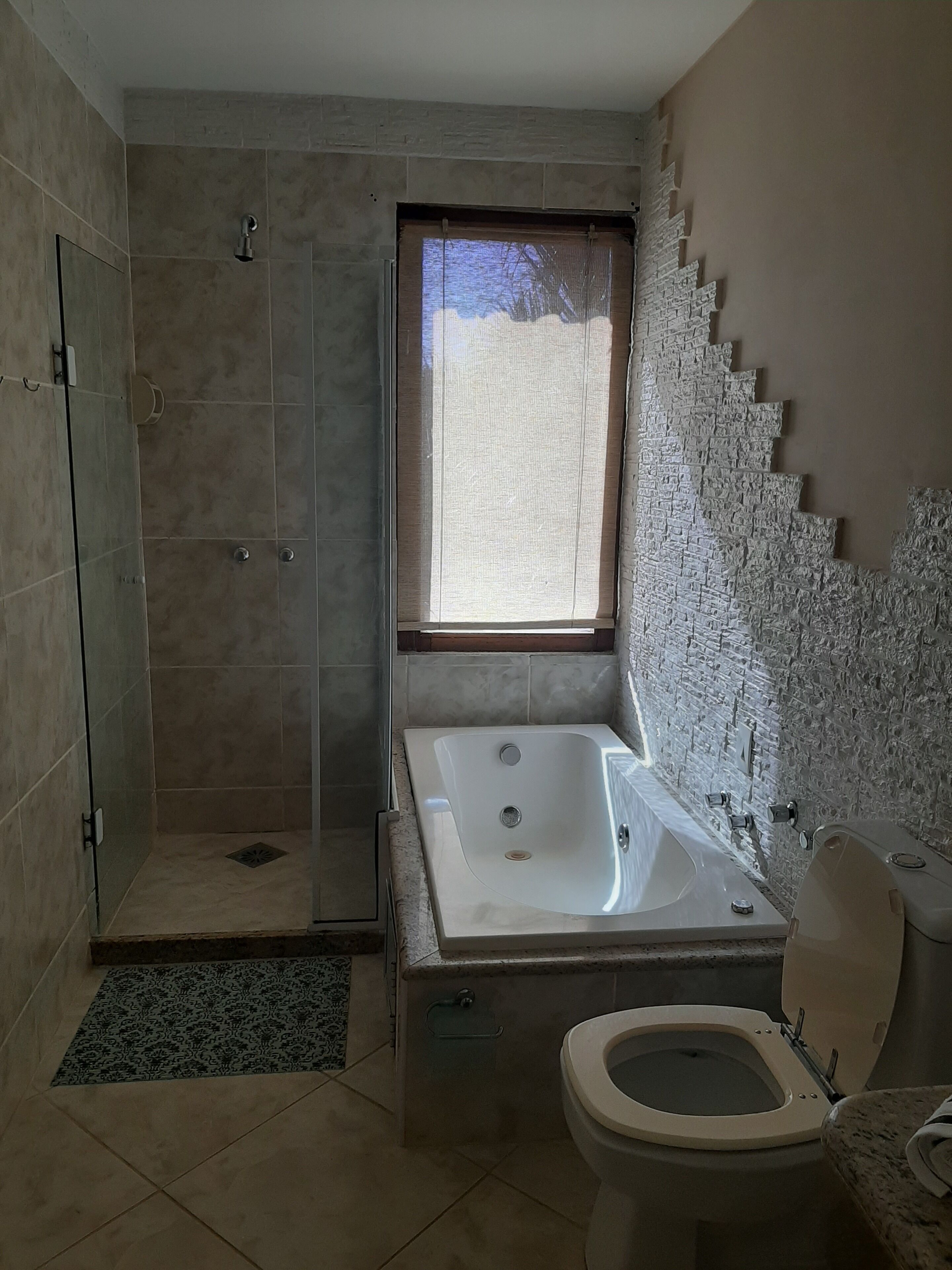 A bathroom with a walk-in shower, a freestanding bathtub, and a toilet.