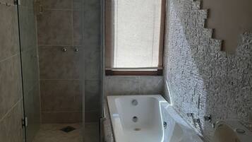 A bathroom with a walk-in shower, a freestanding bathtub, and a toilet.