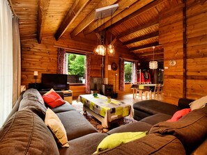 A cozy cabin interior with a wooden interior, a sofa, a television, and a dining area. - Cozy Chalet in Ardennes With Fenced Garden & Covered Terrace (Durbuy)