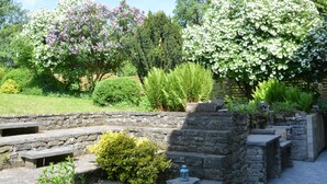 A garden with stone steps, flowering trees, and various shrubs. - Family Retreat, Forested Anhee (Anhée)