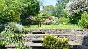 A stone staircase leading up to a garden area with a pergola and various plants. - Family Retreat, Forested Anhee (Anhée)