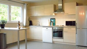 A modern kitchen with white cabinets, a stainless steel refrigerator, a microwave, and a dishwasher. - Elegant Child Friendly Villa in Berismenil near Forest (La Roche-en-Ardenne)