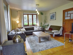 Un salon avec un canapé, une table basse, un radiateur et une fenêtre avec des rideaux.