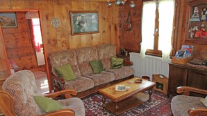 A cozy living room with a wooden interior, a patterned sofa, and a traditional rug. - Boutique Apartment in Valais With Balcony (Guttet-Feschel)