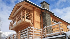 A wooden chalet with a balcony and stone chimney. - Chalet in La Tzoumaz Near Ski Lift (Riddes)
