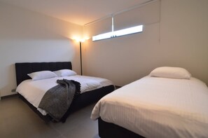 A hotel room with two beds, a bedside lamp, and a ceiling-mounted light fixture. - Modern Holiday Home in Zottegem with Hot Tub (Zottegem)