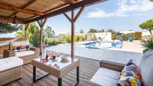 A covered outdoor area with wicker furniture, a pool, and a view of the surrounding landscape. - Villa in Escales With Private Pool (Escales)