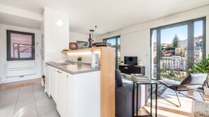 A modern apartment with a kitchen, dining area, and a large balcony with city views. - Martim Moniz Luxury Apartment (Lisboa)