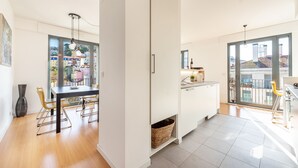 A modern kitchen with a dining area, large windows, and a view of the city. - Martim Moniz Luxury Apartment (Lisboa)