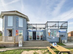 Un edificio de dos plantas con bar, cafetería y alojamiento de tipo B&B.