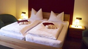 A double bed with white linens and two pillows, a dark headboard, and bedside lamps on either side. - Charming Apartment With Balcony, Garden, BBQ, Parking, Heating (Schmallenberg)