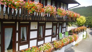 A traditional half-timbered building with flower boxes on the balcony. - Charming Apartment With Balcony, Garden, BBQ, Parking, Heating (Schmallenberg)