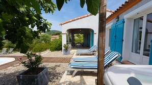 A poolside area with lounge chairs, a hot tub, and a patio with a pergola. - Stylish Family Villa in Felines (Boutenac)