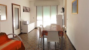 Un ambiente compatto con angolo ristoro, angolo cottura e un letto singolo.