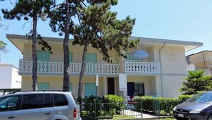 Un edificio di due piani con un balcone, un cartello con la scritta 'LIVENZA' e un'auto parcheggiata davanti.