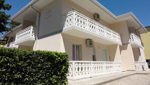 Un edificio a due piani con un balcone al secondo piano.