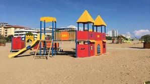 Un'area giochi sulla spiaggia con strutture per arrampicata e scivoli.