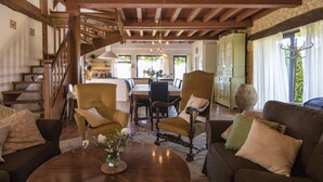 Un vaste espace de vie agrémenté d’un escalier en bois, d’une table à manger et de sièges confortables.