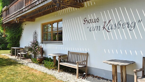 A building with a wooden balcony, a window, and outdoor seating.