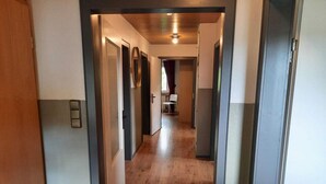A hallway with wooden flooring and doors leading to rooms. - Spacious Apartment in Rattlar near Forest (Willingen)