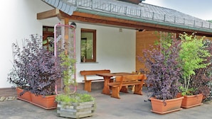 A patio with wooden furniture and potted plants. - Comfortable Holiday Home in Quiet (Balesfeld)