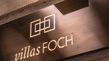 A wooden sign with the text 'villas Foch' and a geometric logo.