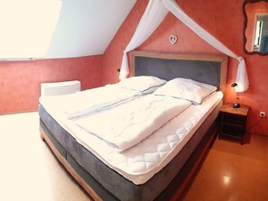 Een slaapkamer met een bed, een nachtkastje en een bedtafel.