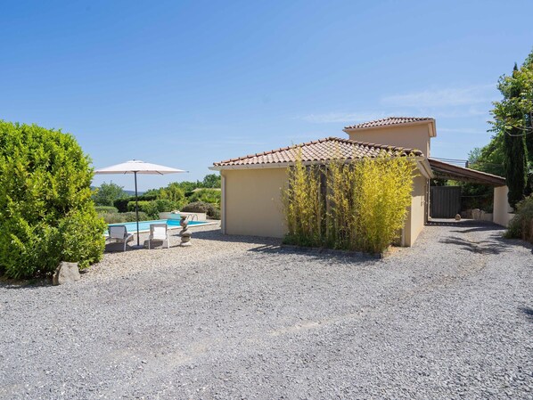 A residential property with a swimming pool, outdoor seating, and a gravel driveway. - Charming Villa Near Les Vans (Les Vans)