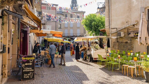 A cobblestone street with outdoor cafes, a sign for 'Tangada' selling artisanal ice cream, and a church spire in the background. - Charming Villa Near Les Vans (Les Vans)