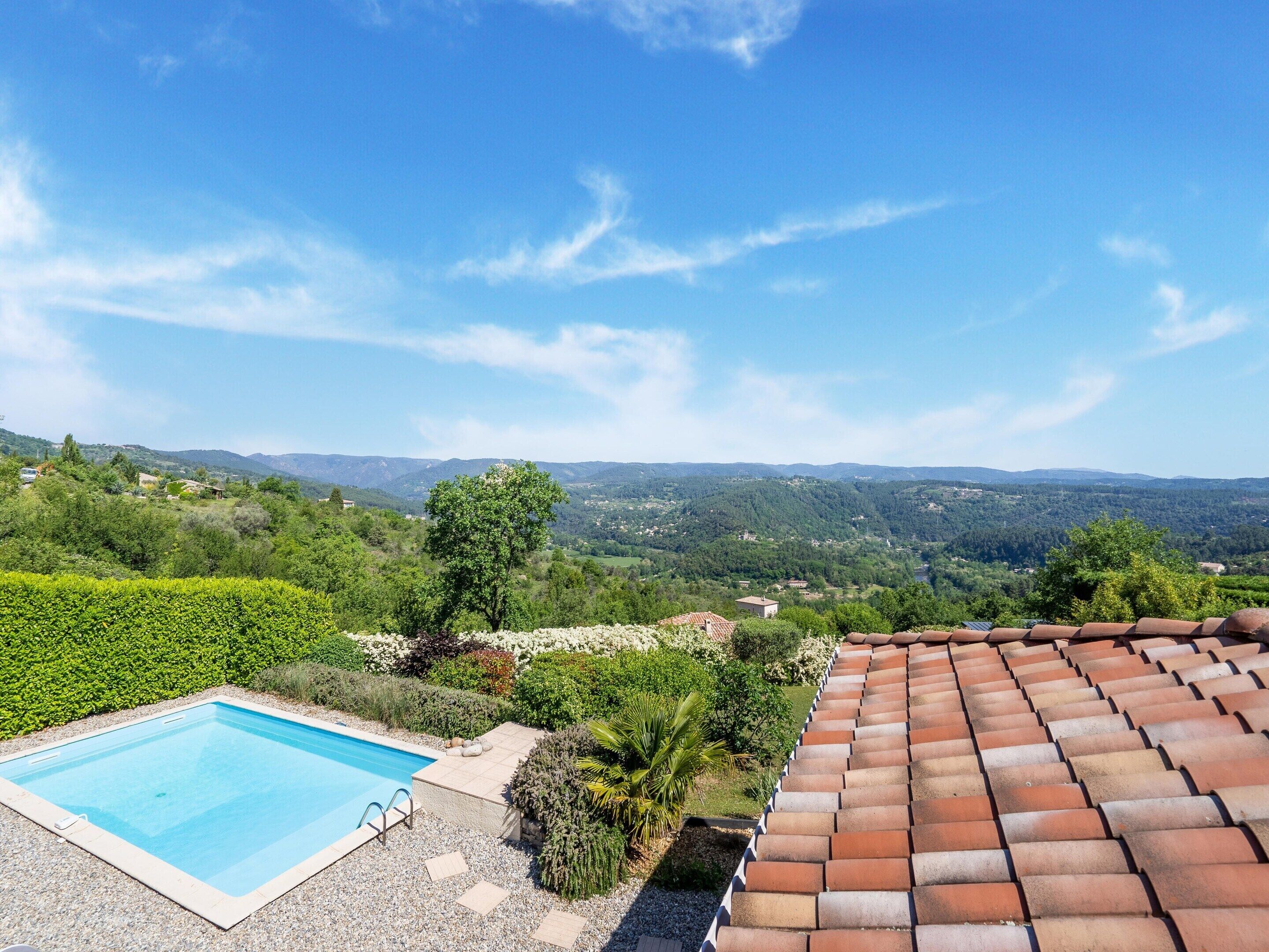 A swimming pool with a view of a hilly landscape.