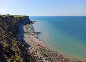 A coastal landscape with a cliff and beach. - Seaside Stay in Saint-clement (Osmanville)