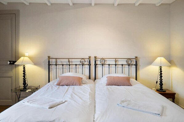 A double bed with a metal headboard, two bedside tables with lamps, and a white wall. - Manor in Normandy With Spa and Pool (Ponts sur Seulles)