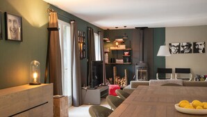 A modern living room with a dining table, sofa, and television. - Villa Near Les Vans With Private Pool (Les Salelles)