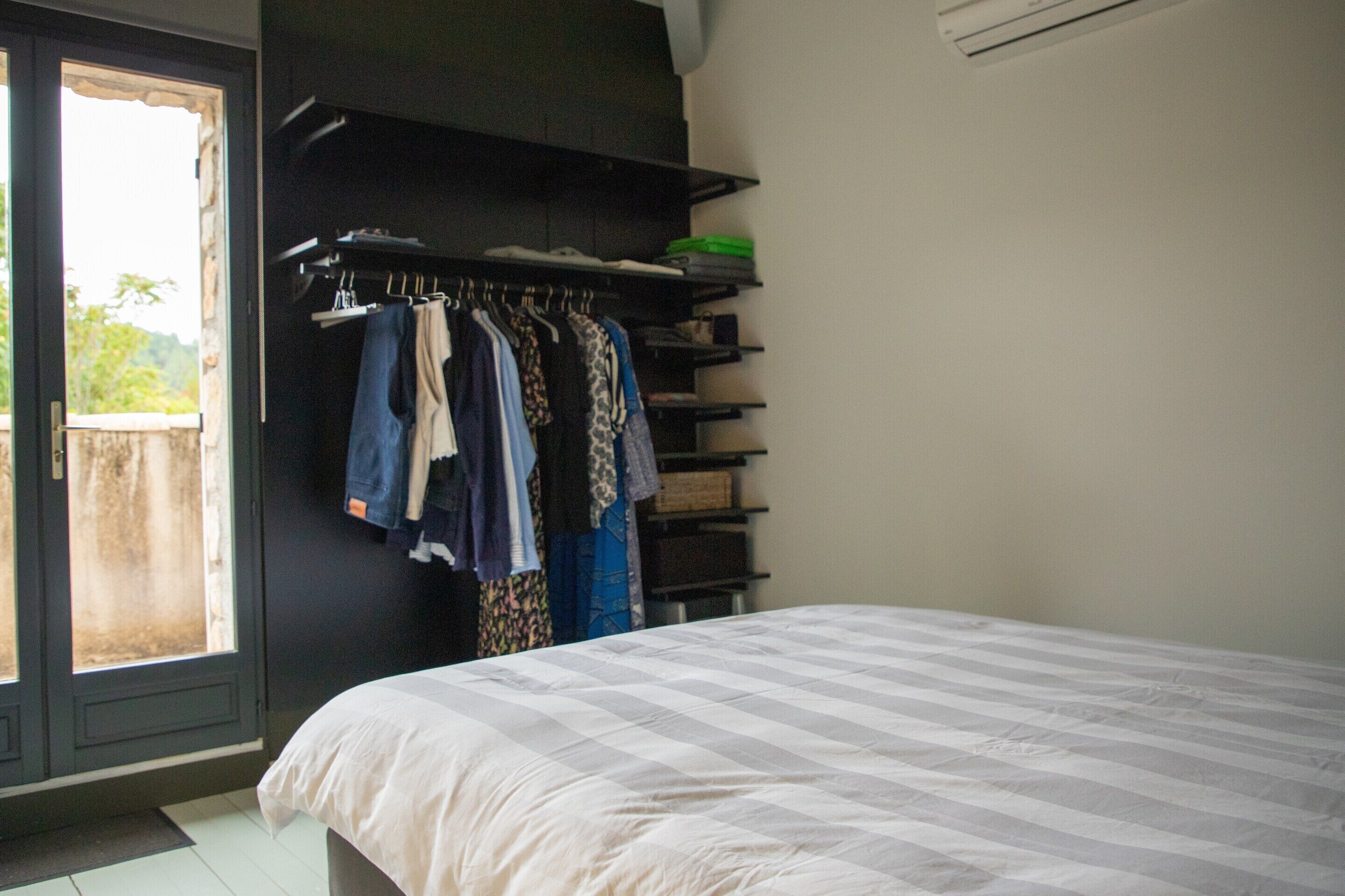 Ein Schlafzimmer mit Bett, Kleiderschrank und Fenster.