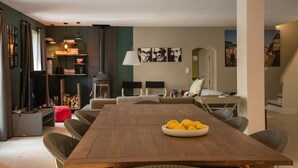 A dining area with a wooden table, chairs, and a bowl of lemons. - Villa Near Les Vans With Private Pool (Les Salelles)