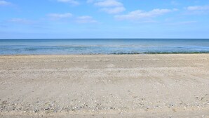 Ein Strand mit blauem Himmel und ruhigem Meer.