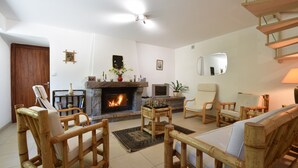 A living room with a fireplace, wooden furniture, and a staircase. - Charming Brittany Hideaway (Yvias)