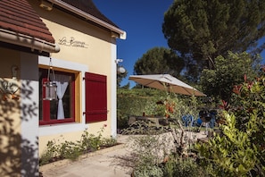 A building with a sign reading 'La Roselle Roselle,' a window with red shutters, and a garden area with a barbecue setup. - Family Home in Carsac-aillac (Carsac-Aillac)