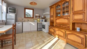 A kitchen with white appliances, a wooden cabinet with glass doors, and a window. - House in Perigord Near Medieval Villages (Prats-du-Perigord)