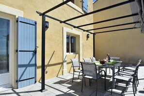 An outdoor patio with a table, chairs, and a pergola structure. - Peaceful Poolside Escape (Montouliers)