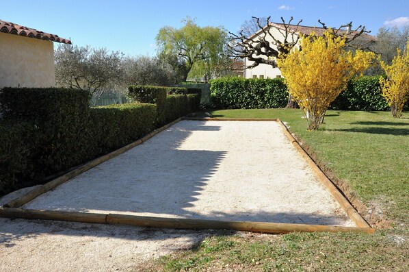 A courtyard with a gravel path, a hedge, and a tree with yellow leaves. - Luxury Villa With Private Pool (Saint-Victor-de-Malcap)