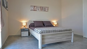 A bedroom with a bed, nightstands, a wall-mounted artwork, and a door. - Luxury Villa With Private Pool (Saint-Victor-de-Malcap)