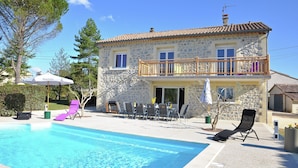 A stone building with a balcony, a swimming pool, and outdoor seating. - Luxury Villa With Private Pool (Saint-Victor-de-Malcap)