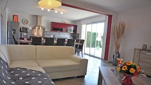 A modern living room with a sofa, a dining area with chairs, a kitchen with cabinets, and a large window. - Luxury Villa With Private Pool (Saint-Victor-de-Malcap)