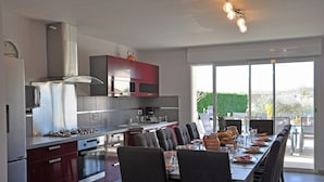 A modern kitchen with a dining area, large windows, and a view of the outdoors. - Luxury Villa With Private Pool (Saint-Victor-de-Malcap)