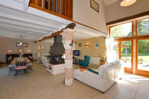 A spacious living area with a fireplace, a dining table, and a comfortable seating arrangement.